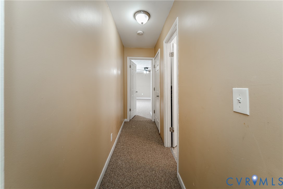 26746 Oxford Road Ruther Glen, VA 22546 - Photo 18 of 25 a view of a hallway with wooden floor and a bathroom