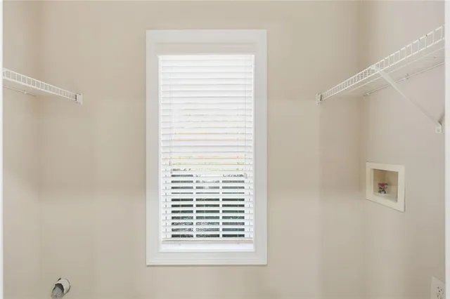 an empty room with wooden floor fireplace and windows