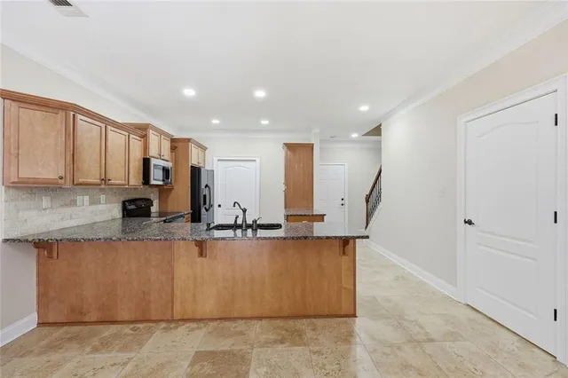 a kitchen with stainless steel appliances granite countertop a sink stove microwave and refrigerator