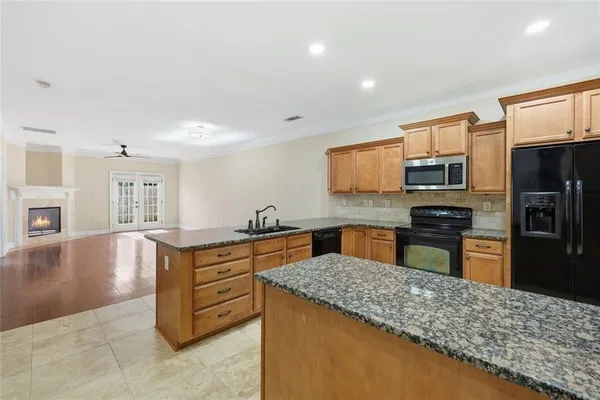 a large kitchen with kitchen island granite countertop a large counter top and stainless steel appliances