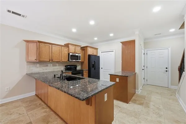 a kitchen with stainless steel appliances granite countertop a sink and cabinets