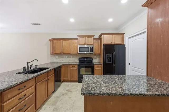 a kitchen with stainless steel appliances granite countertop a sink and cabinets