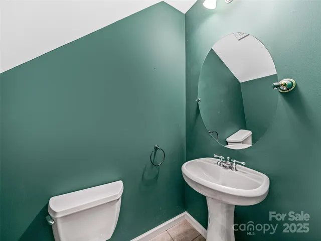 a view of kitchen and empty room with wooden floor