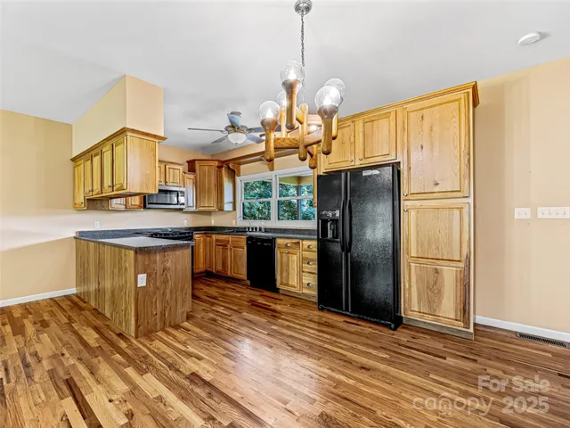 a kitchen with granite countertop a sink a counter space stainless steel appliances and cabinets