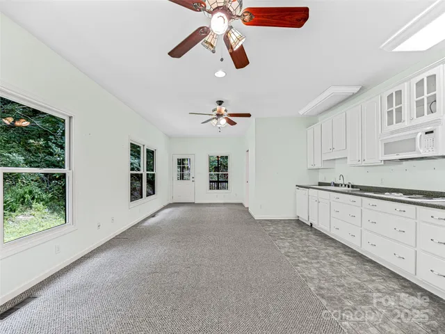 a view of an empty room with a window and a ceiling fan
