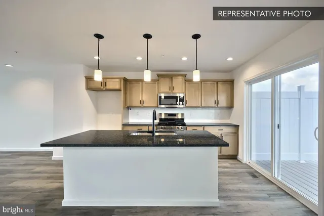 a kitchen with kitchen island granite countertop a sink a counter space and cabinets