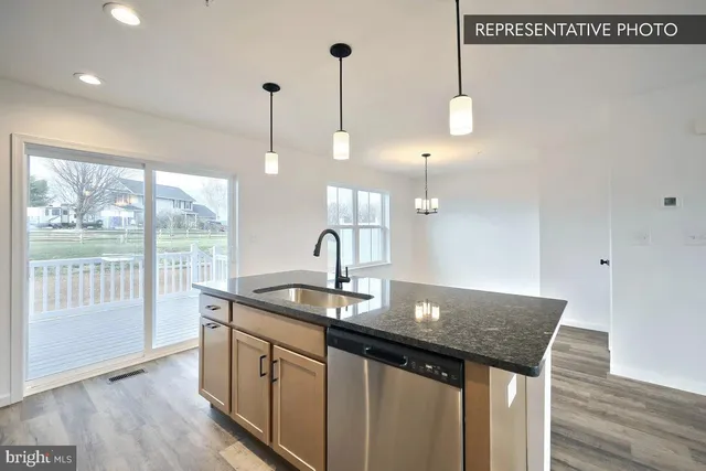 a kitchen with a sink cabinets and wooden floor