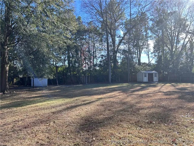 a view of a yard with large trees
