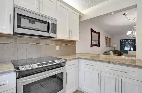 a kitchen with granite countertop cabinets stainless steel appliances and a sink