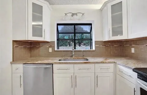 a kitchen with a sink cabinets and window
