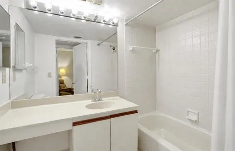 a bathroom with a bath tub sink and mirror