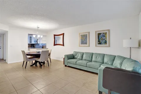 a living room with furniture and a dining table with chair
