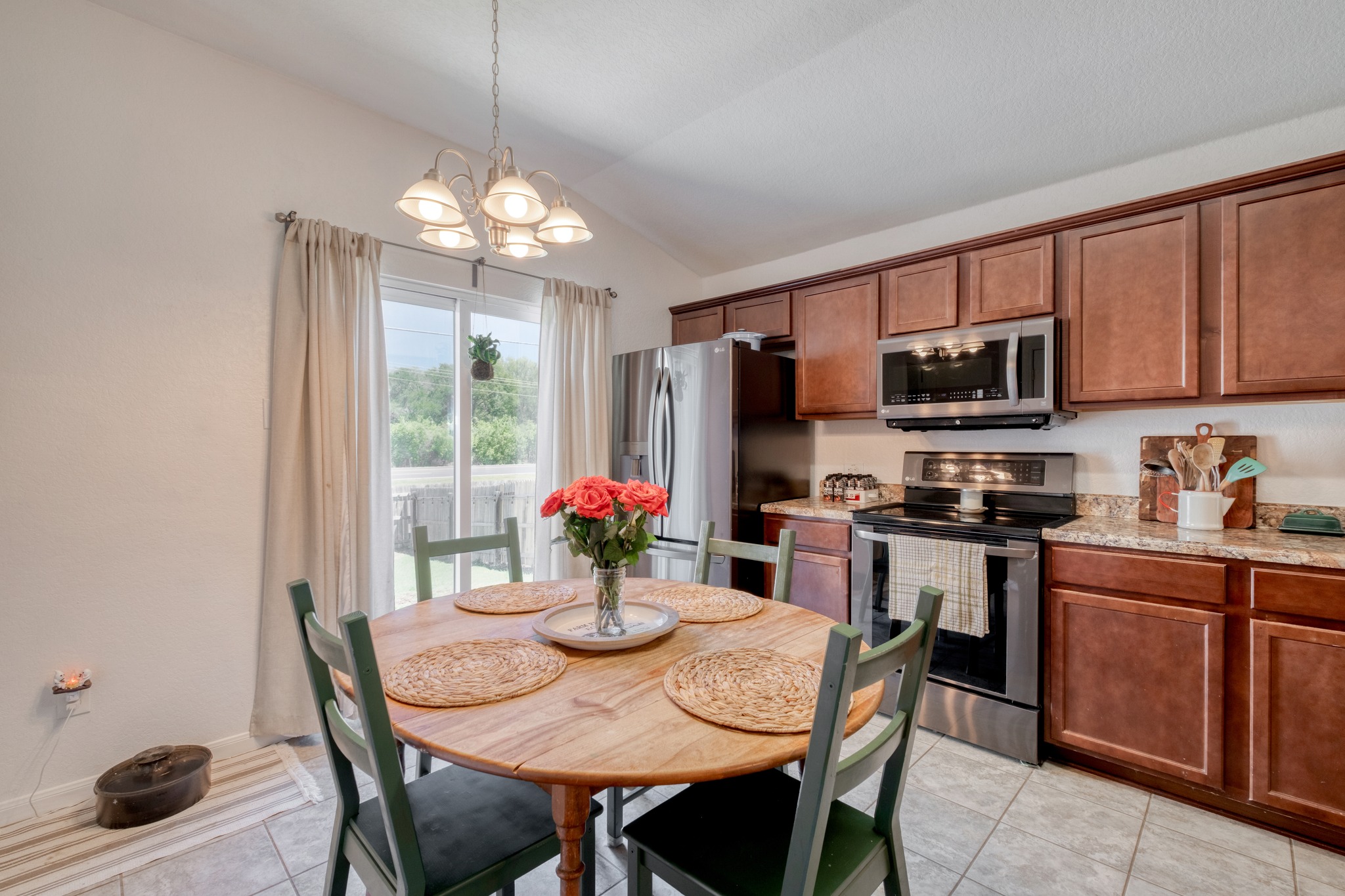 174 Falcon Drive Luling, TX 78648 - Photo 13 of 38 Kitchen featuring stainless steel appliances, wood finish cabinetry, light stone counters, hanging lights, and lofted ceiling