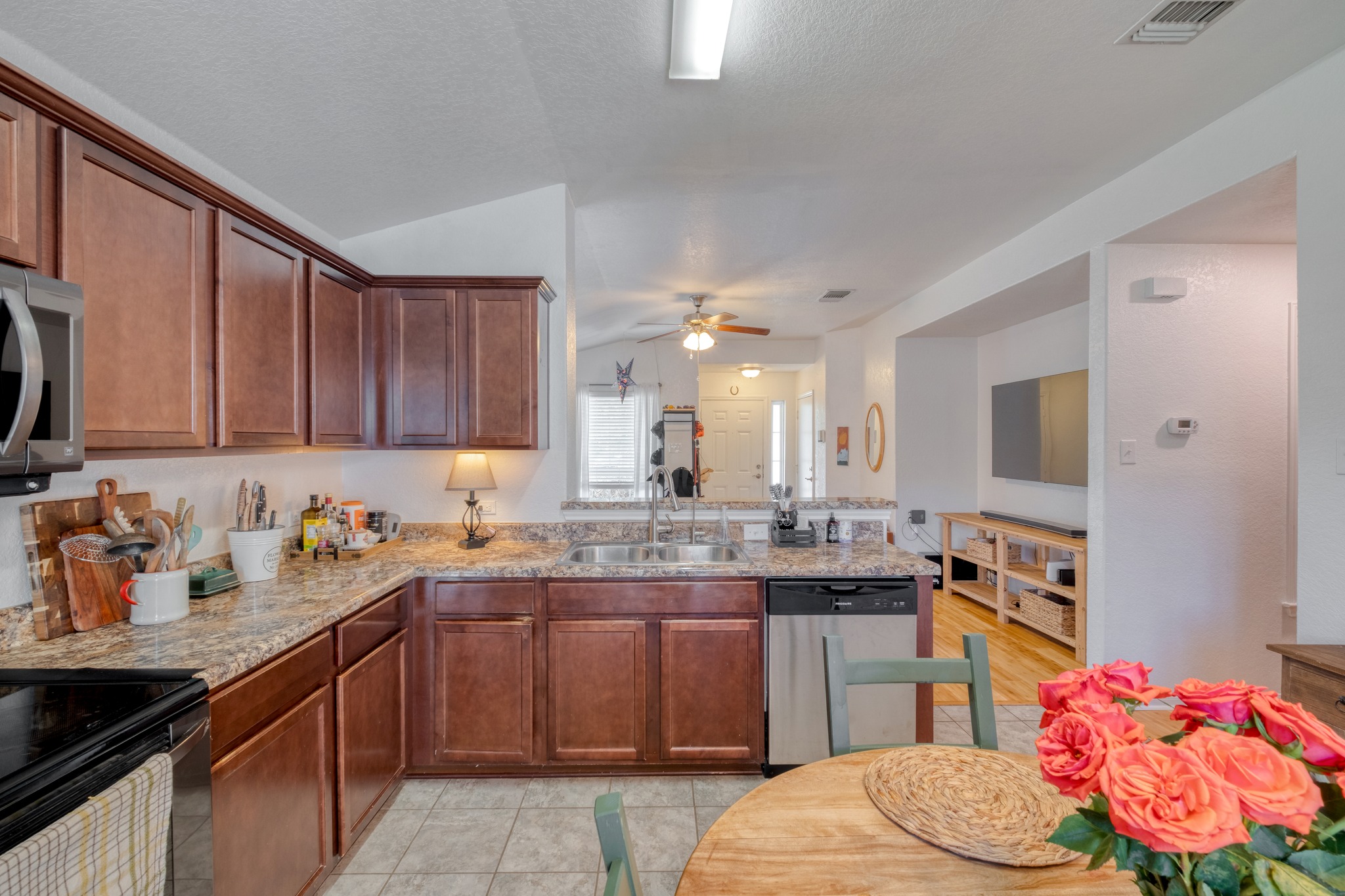 174 Falcon Drive Luling, TX 78648 - Photo 14 of 38 Kitchen featuring stainless steel appliances, lofted ceiling, ceiling fan, light stone countertops, and light tile patterned floors