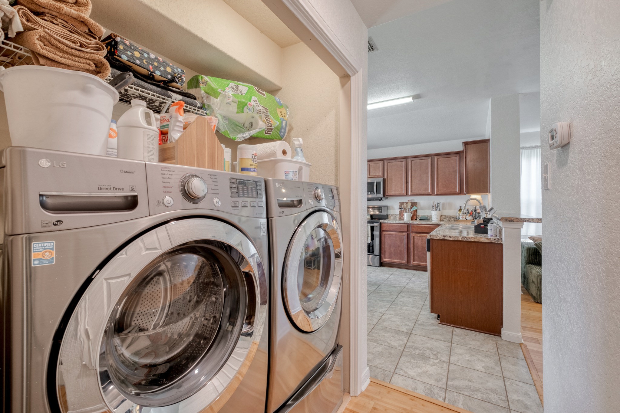 174 Falcon Drive Luling, TX 78648 - Photo 21 of 38 Laundry area with a textured wall, washing machine and dryer, and light wood finished floors