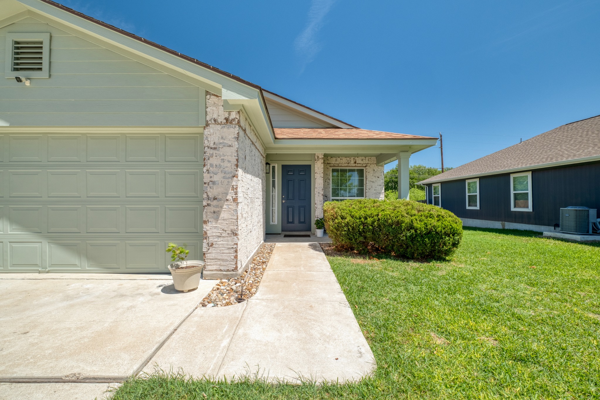 174 Falcon Drive Luling, TX 78648 - Photo 3 of 38 Entrance to property with a lawn, covered porch, an attached garage, and brick siding