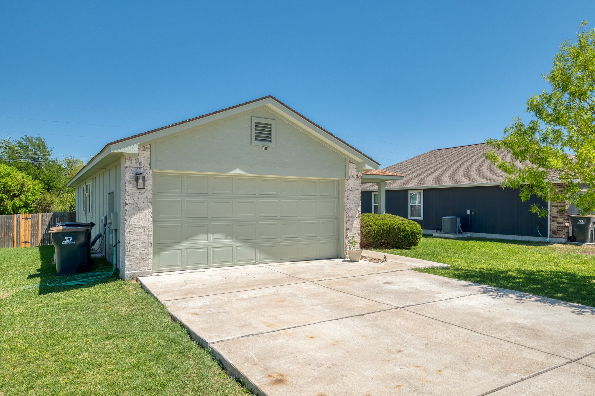 174 Falcon Drive Luling, TX 78648 - Photo 4 of 38 View of front of property featuring a front lawn, driveway, a garage, an outbuilding, and brick siding