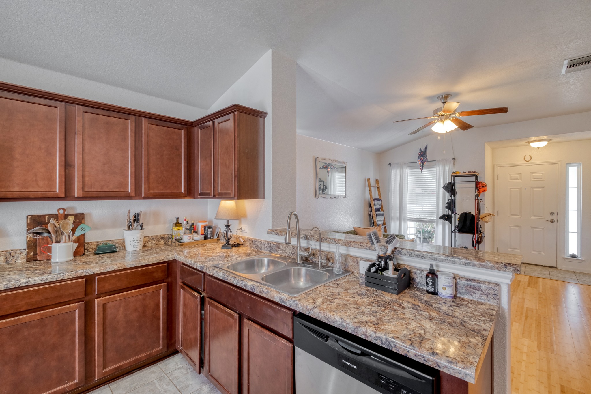 174 Falcon Drive Luling, TX 78648 - Photo 10 of 38 Kitchen featuring dishwasher, a peninsula, a ceiling fan, wood finish cabinets, and lofted ceiling