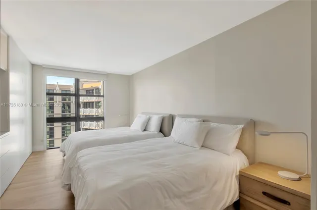 a bedroom with a bed and a large window