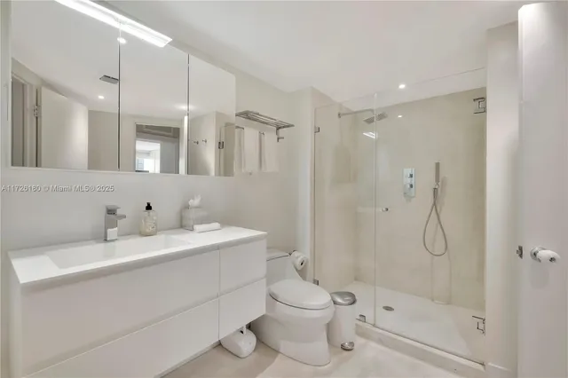 a bathroom with a double vanity sink toilet mirror and shower