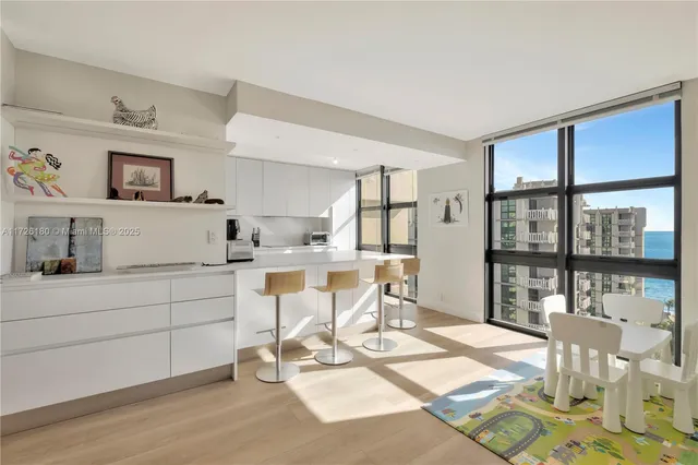 a living room with furniture a floor to ceiling window and floor to ceiling window