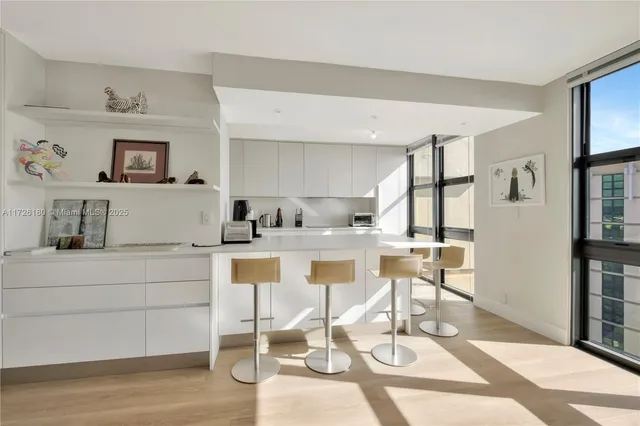 a kitchen with stainless steel appliances kitchen island granite countertop a table and chairs in it