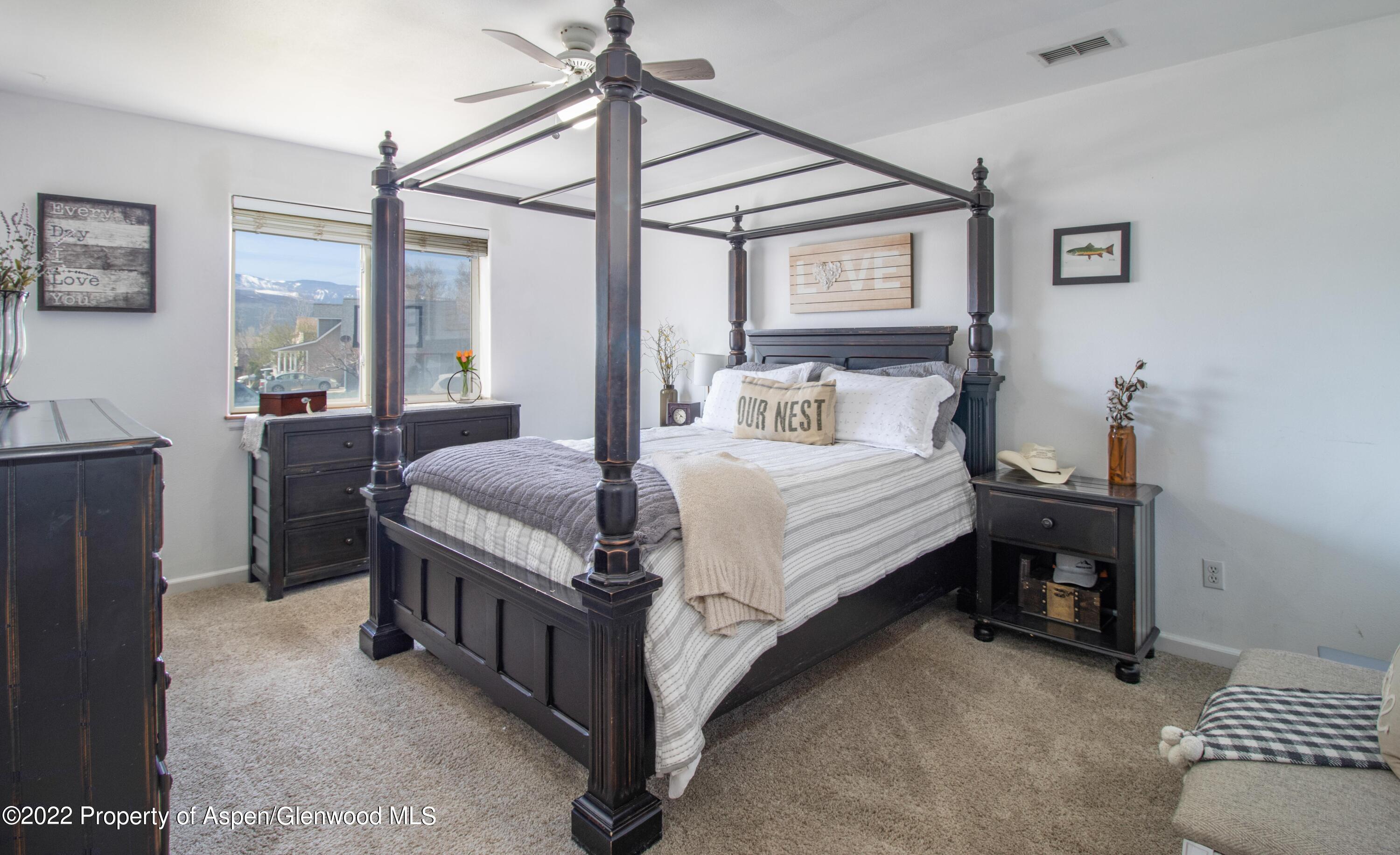 1575 Balsam Court Rifle, CO 81650 - Photo 7 of 14 a large bedroom with a bed and a chandelier