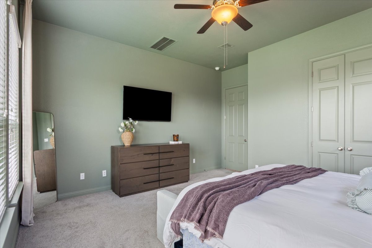 424 Millard Street Georgetown, TX 78628 - Photo 18 of 37 A tranquil bedroom provides comfort with soft carpeting and a ceiling fan for ideal airflow.