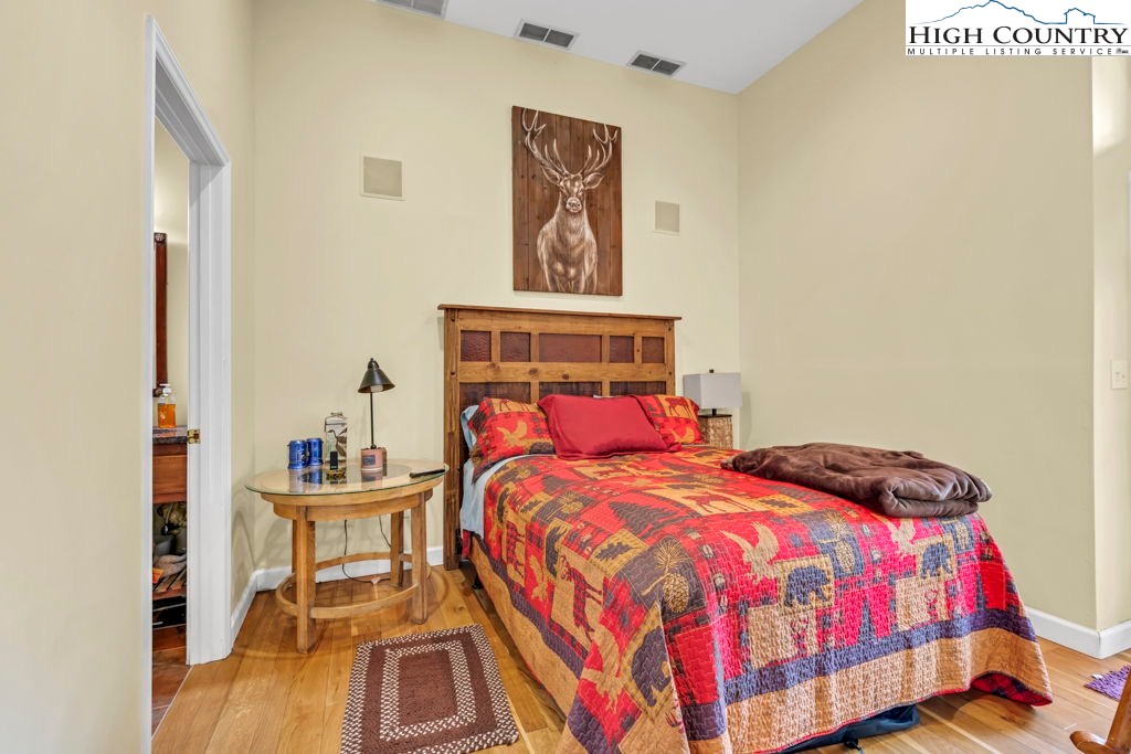 404 Running Deer Trail Boone, NC 28607 - Photo 24 of 38 a bedroom with a bed and wooden floor