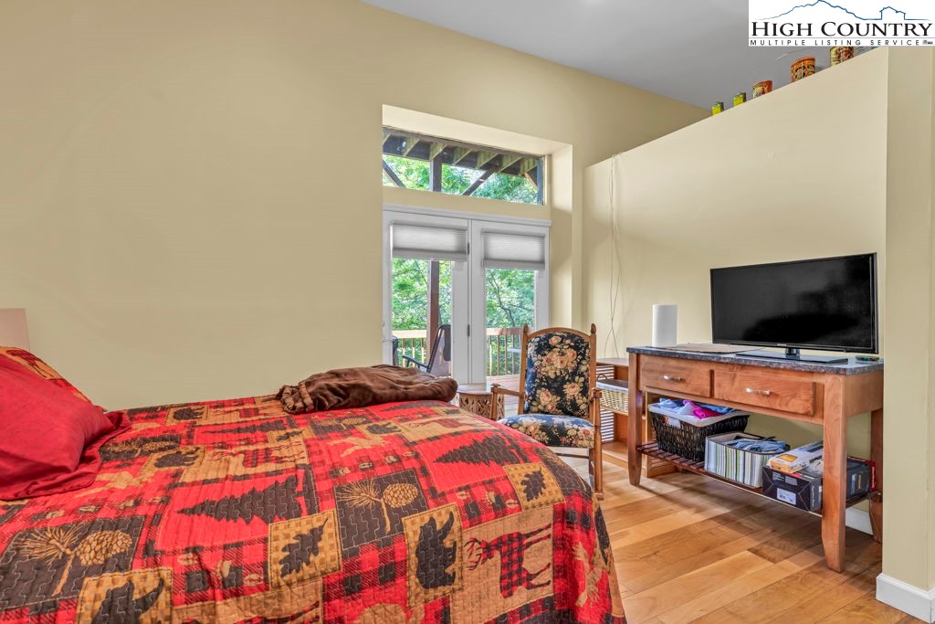 404 Running Deer Trail Boone, NC 28607 - Photo 30 of 38 a bedroom with a bed and a flat screen tv