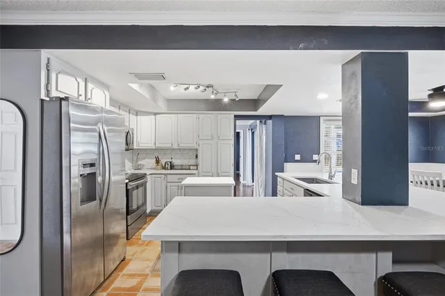 a kitchen with refrigerator and cabinets