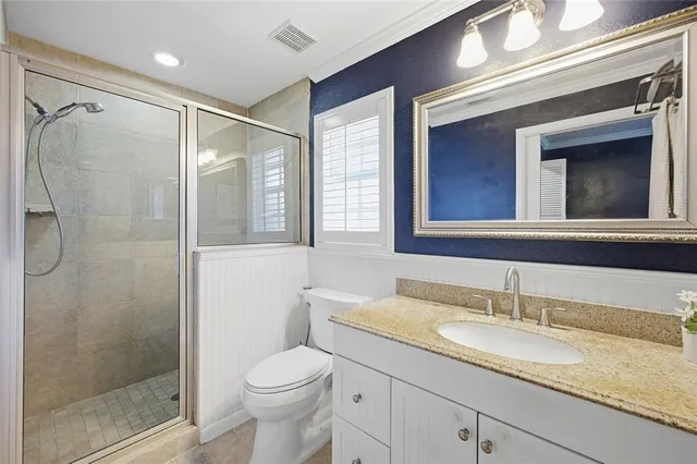 a bathroom with a granite countertop sink toilet and shower