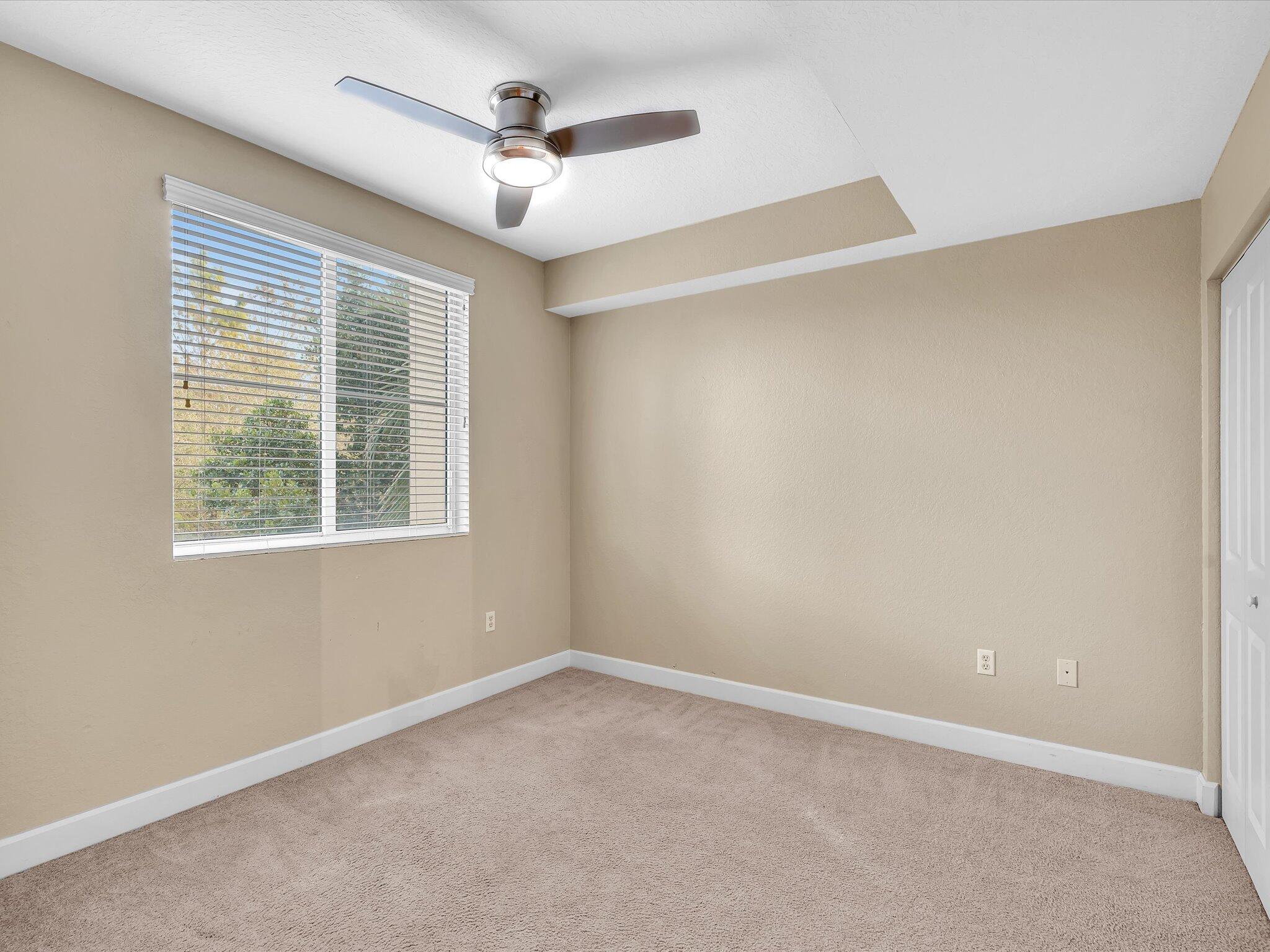 4303 Renaissance Way, Unit 303 Boynton Beach, FL 33426 - Photo 32 of 74 an empty room with a window and a ceiling fan