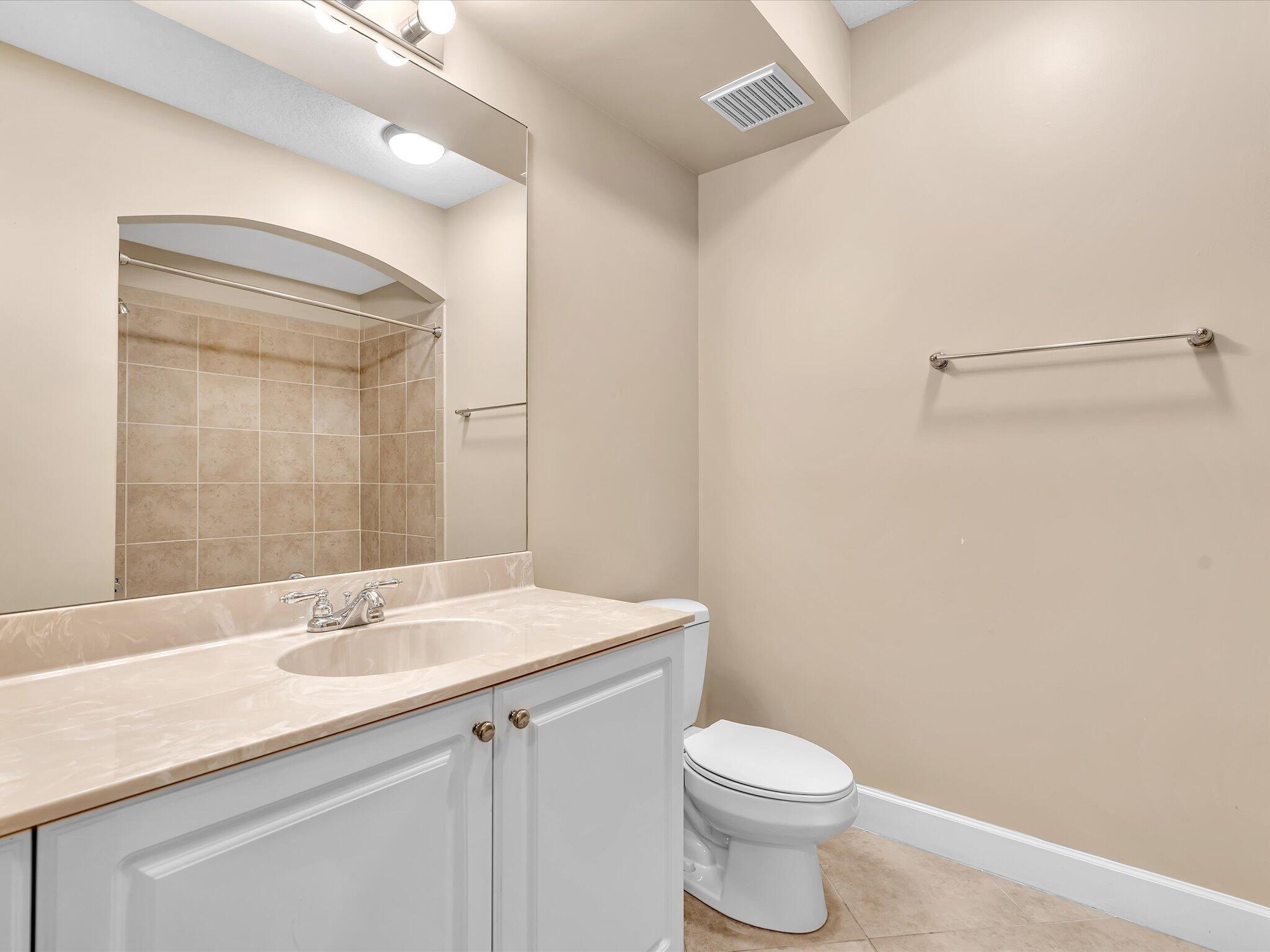 4303 Renaissance Way, Unit 303 Boynton Beach, FL 33426 - Photo 37 of 74 a bathroom with a granite countertop sink a toilet and a mirror