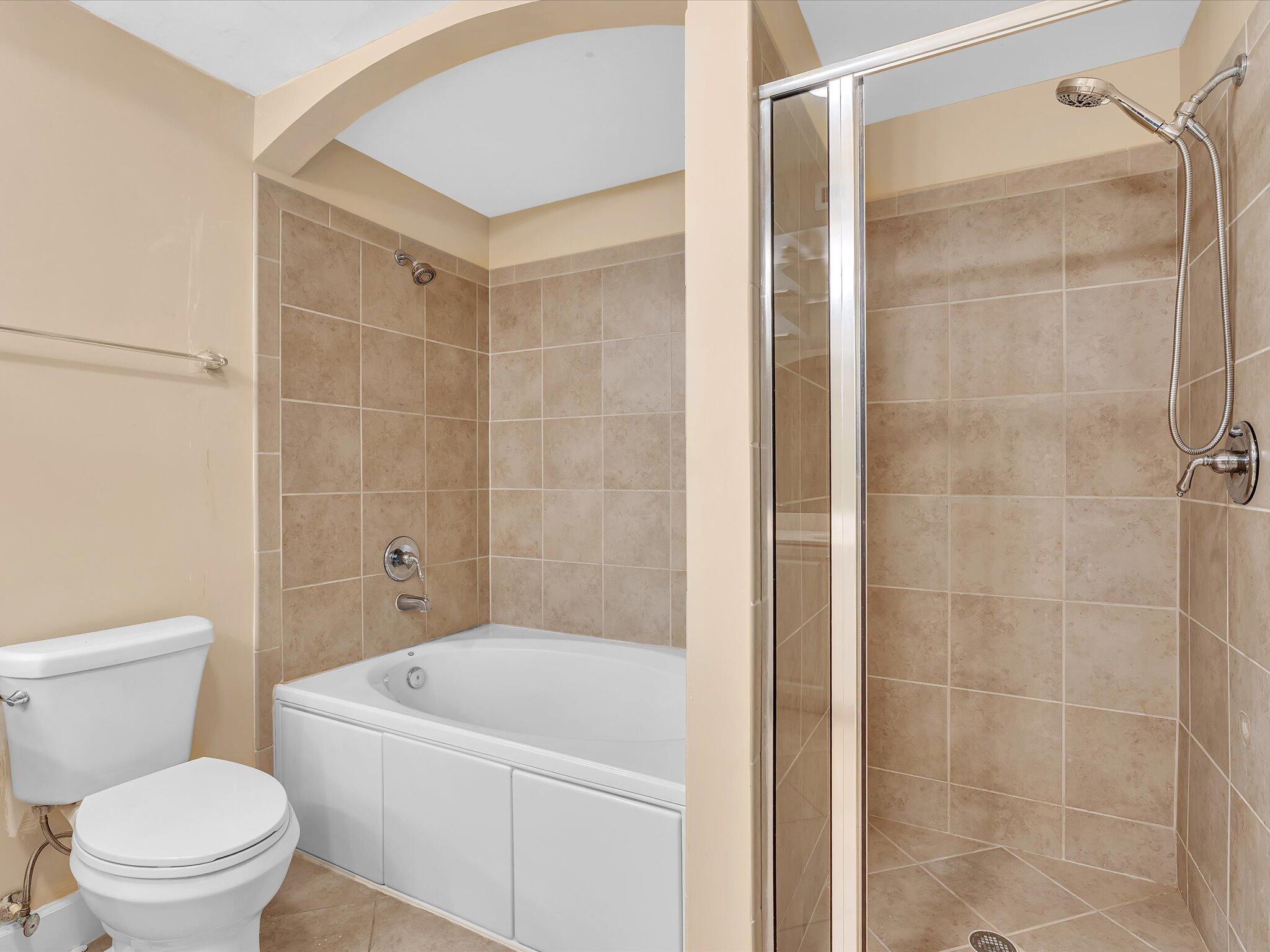 4303 Renaissance Way, Unit 303 Boynton Beach, FL 33426 - Photo 51 of 74 a white toilet sitting next to a bathroom sink and a shower