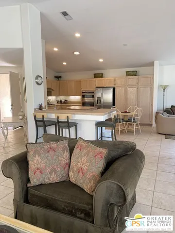 a living room with stainless steel appliances kitchen island granite countertop furniture and a view of kitchen