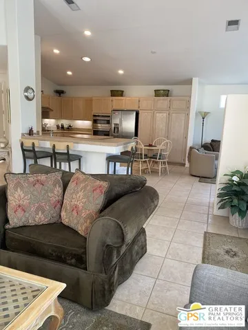 a living room with couches and kitchen view with kitchen view