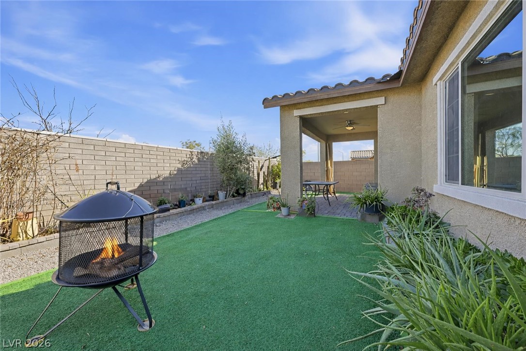 250 Dedication Avenue Henderson, NV 89011 - Photo 42 of 67 Fenced backyard featuring a patio area, an outdoor fire pit, and ceiling fan
