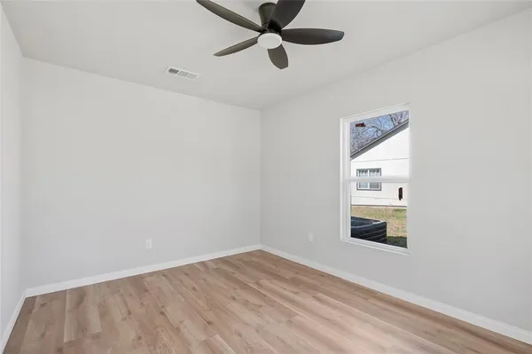 a view of an empty room with wooden floor