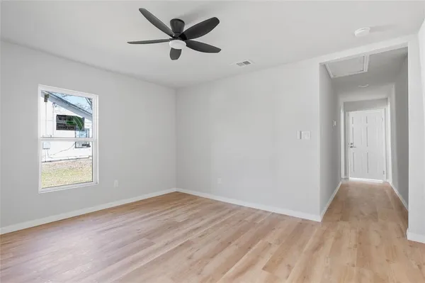 a view of a big room with wooden floor and a ceiling fan