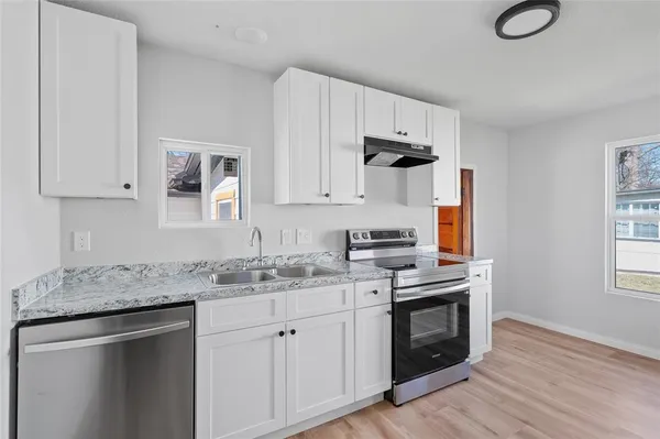 a kitchen with appliances cabinets and a wooden floor