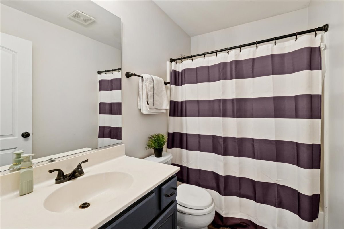 60 Wingate Drive, Unit 60 Oswego, IL 60543 - Photo 16 of 23 a bathroom with a sink a toilet a shower curtain and a mirror