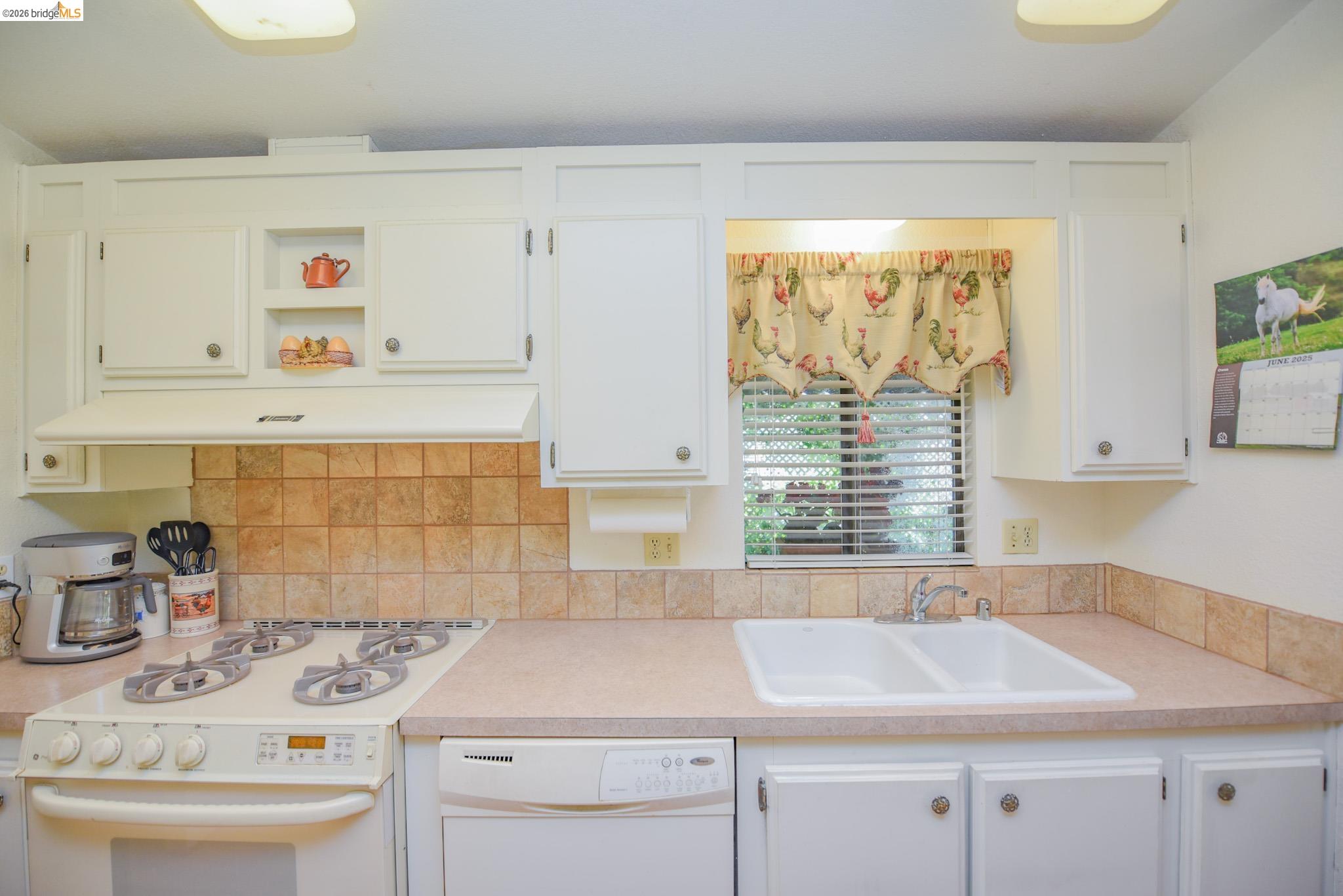 18717 Mill Villa Road, Unit 235 Jamestown, CA 95327 - Photo 12 of 24 Kitchen with white appliances, open shelves, light countertops, white cabinets, and exhaust hood