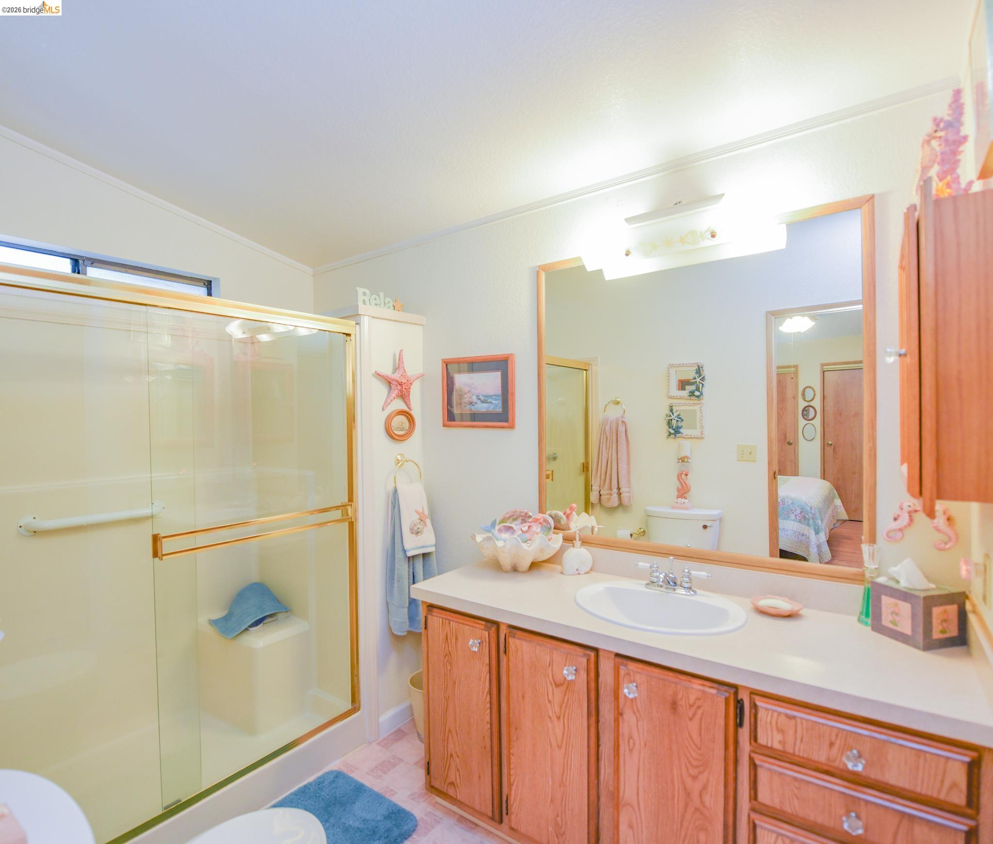 18717 Mill Villa Road, Unit 235 Jamestown, CA 95327 - Photo 15 of 24 Ensuite bathroom featuring a shower stall, vanity, vaulted ceiling, and crown molding