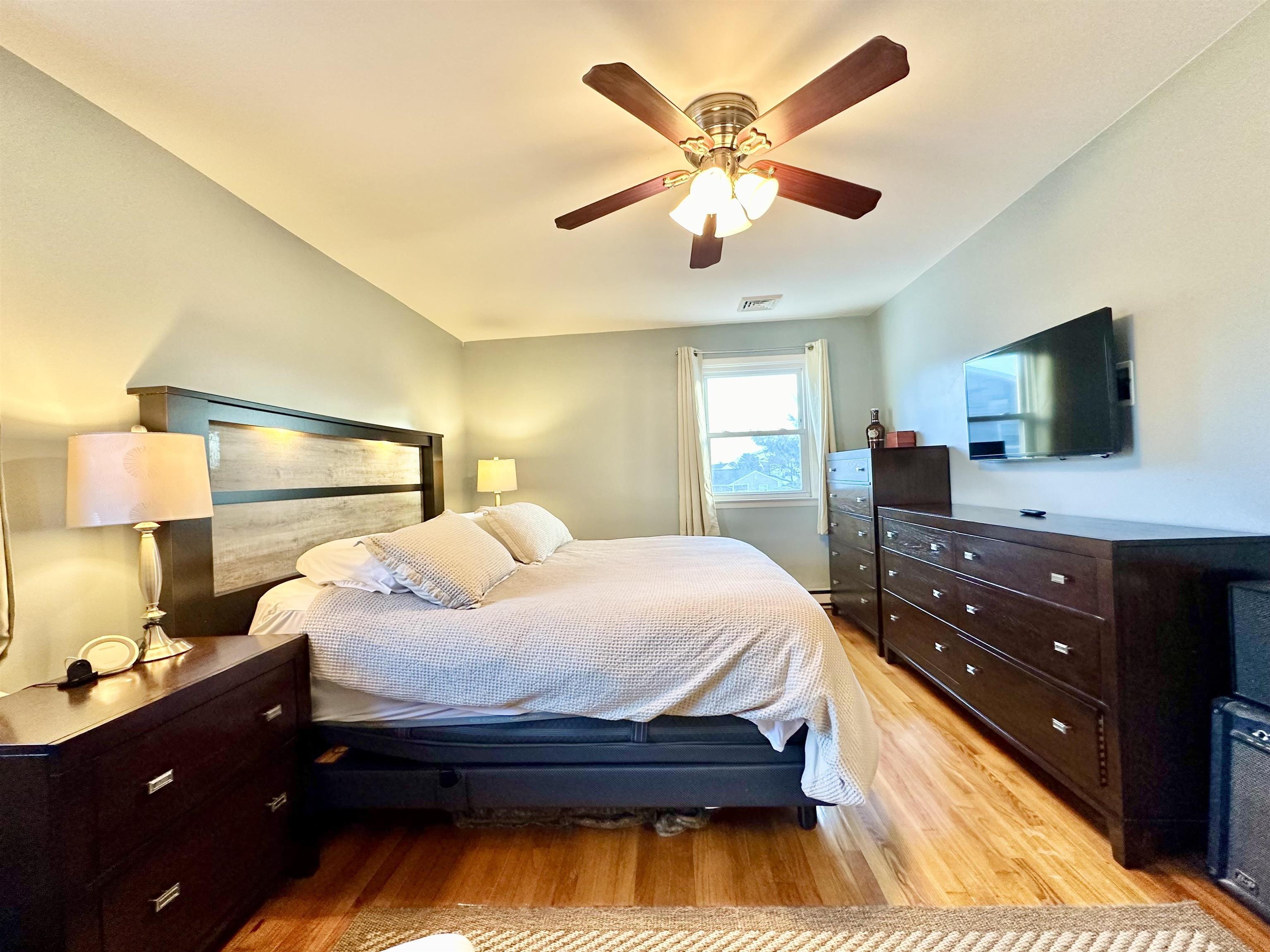 12 Explorer Road Brigantine, NJ 08203 - Photo 20 of 44 a bedroom with a bed and a flat tv screen on dresser