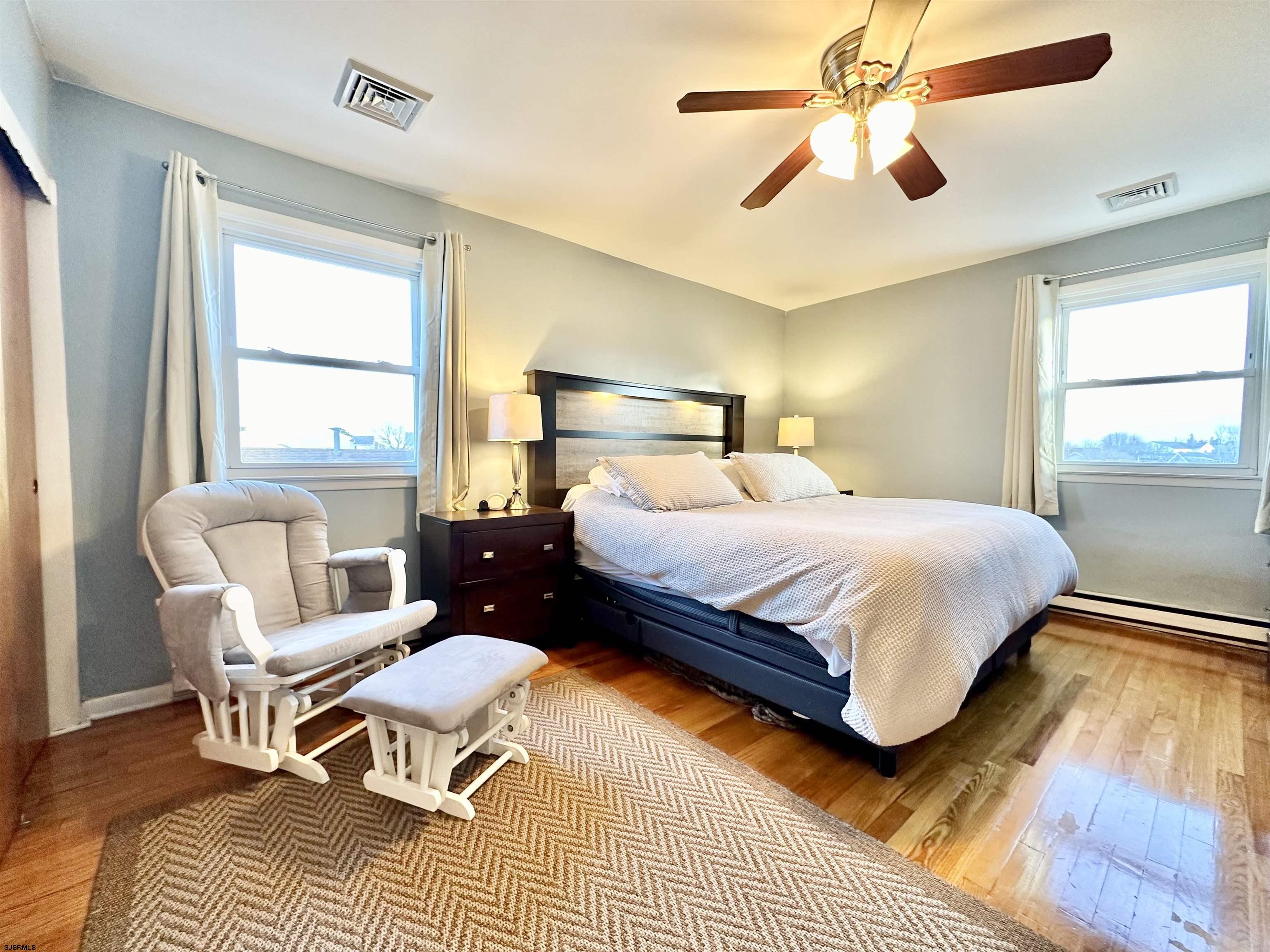 12 Explorer Road Brigantine, NJ 08203 - Photo 21 of 44 a bedroom with a bed a chandelier and a window