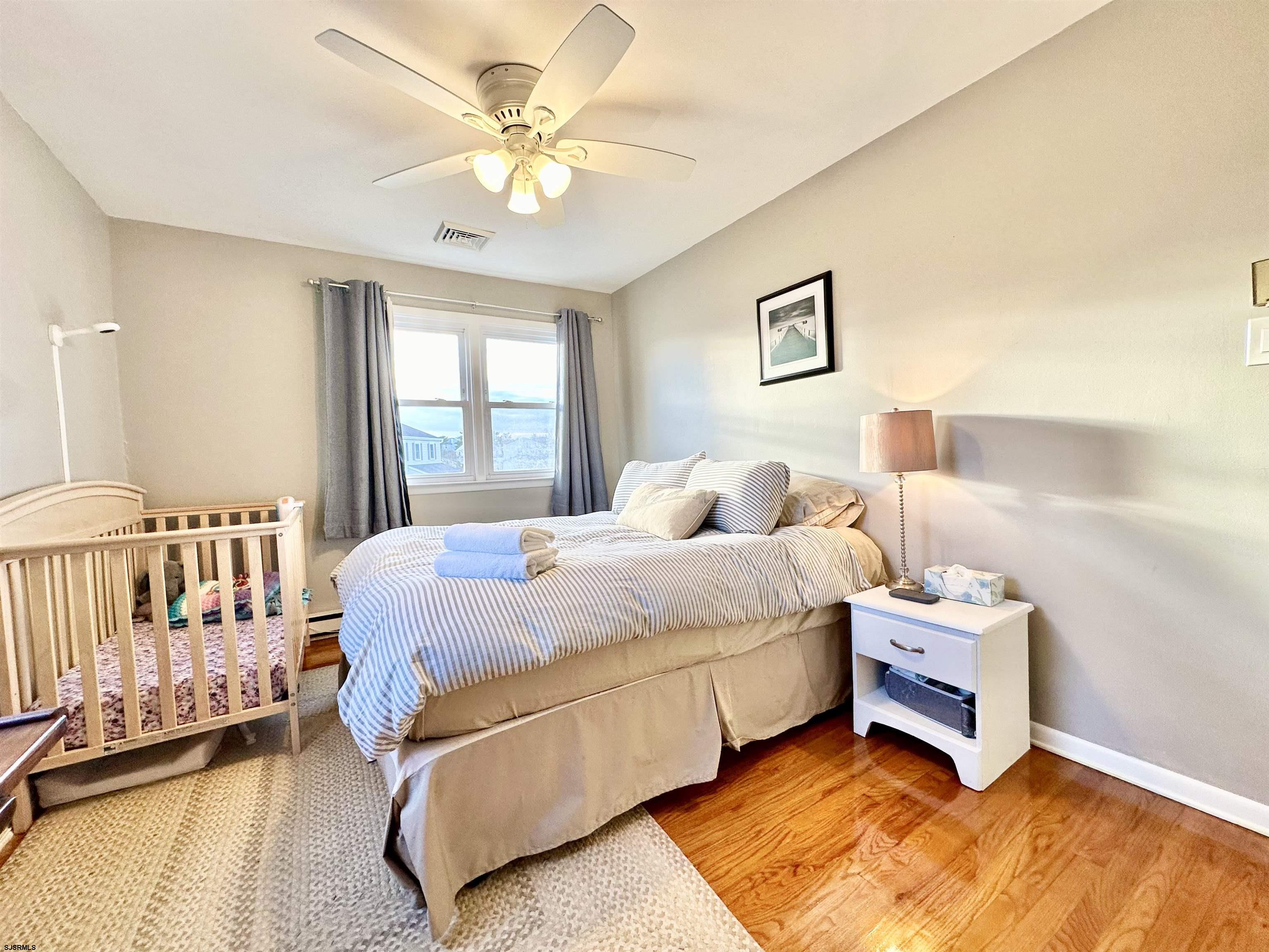 12 Explorer Road Brigantine, NJ 08203 - Photo 23 of 44 a bedroom with a bed and a chandelier