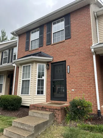 a front view of a brick house with a yard