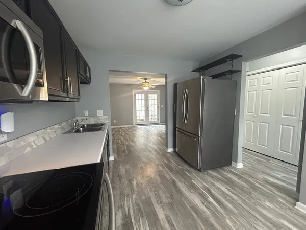 a kitchen with stainless steel appliances a sink a stove a refrigerator and cabinets