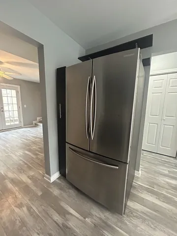 a view of a refrigerator in kitchen and wooden floor